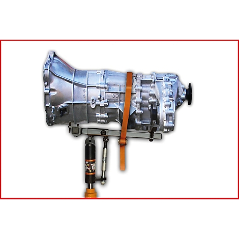 Eine silberfarbene Getriebebaugruppe wird von einem orangefarbenen Gurt gesichert, der auf einer hydraulischen Hebebühne angebracht ist.